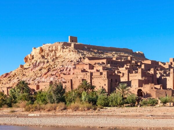 a small town on a hill with Aït Benhaddou in the background