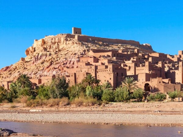 a small town on a hill with Aït Benhaddou in the background