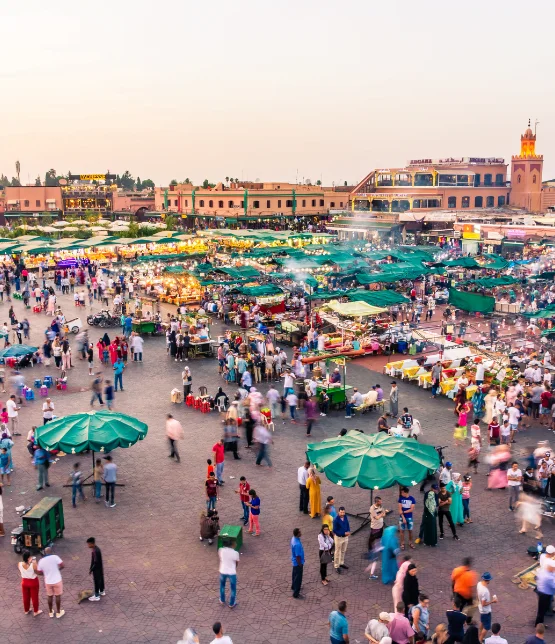 a large crowd of people in a square with tents and tents