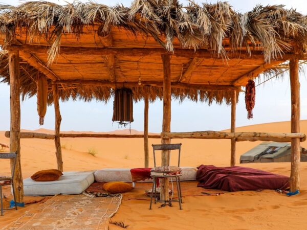a straw covered shelter in a desert