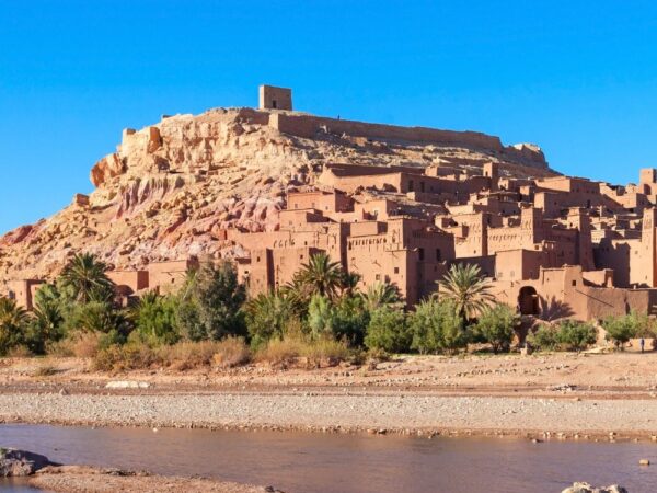 a small town on a hill with Aït Benhaddou in the background