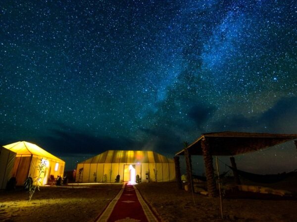 a tent and a walkway in the middle of a desert