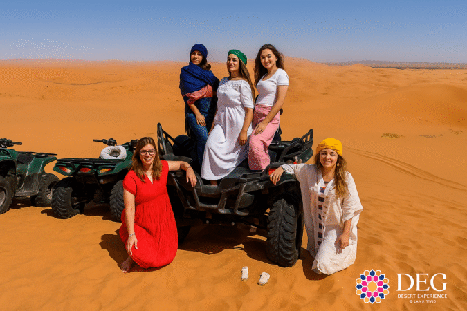 Group enjoying sunset atv quad biking in the Sahara desert dunes Merzouga